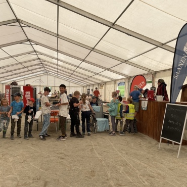 Mini-Gstaad: «Hier regieren wir Kinder!»   - Anstehen am Bankschalter, um sich den Lohn ausbezahlen zu lassen. 