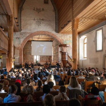 Wenn Beethovens Musik Bilder bekommt - Die Schulkinder hören Beethovens 6. Symphonie und verfolgen in der Kirche die Projektionen. (Fotos:  Raphael Faux/Gstaadphotography.com)