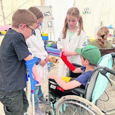 Mini-Gstaad 2025: So haben wir Kinder regiert - Konzentration im Spital: Jetzt erst einmal einen fachmännischen Verband anlegen.