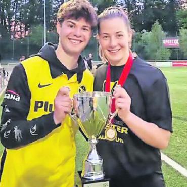 Fussball im Mittelpunkt - Sina Hauswirth strahlt wie der Pokal in ihren Händen. Mit ihr freut sich Bruder Sandro über den Erfolg ihres Teams. FOTO: ZVG