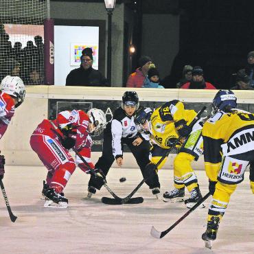 Packendes Hockey der höchsten Schweizer Spielklasse in Gstaad - Bully in der Offensivzone von Langenthal. Im Hintergrund sieht man einige der knapp 350 Zuschauer.