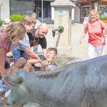 Eine kalte Dusche für die Berufsehre - Frisch «gegautscht»: Noah Bill erhielt von seinen Kolleginnen und Kollegen die Taufe und ist nun ein Mitglied der Gilde Gutenbergs. FOTOS: JOCELYNE PAGE