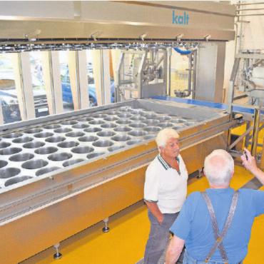 Einblick in die neue Molkerei Gstaad - Besucher vor der Käsepresse für 90 Laib Käse (rund oder eckig).