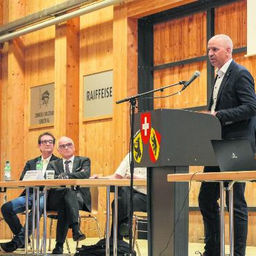 Spital Zweisimmen im Wandel: Was sich für die Bevölkerung ändert - David Roten (am Podium), CEO der Spital STS AG, orientierte das Publikum über die Herausforderungen am Standort Zweisimmen und wie das Unternehmen diese angehen will. Im Hintergrund (von links) Gundekar Giebel, Leiter Kommunikation der kantonalen Gesundheits-, Sozial- und Integrationsdirektion, und Regierungsrat Pierre Alain Schnegg.
