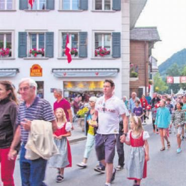 Über die Vorbereitungen eines Festredners - Die Besuchenden folgten dem Umzug durch das Dorf Saanen (oben), um am Ende das 1.-August-Feuer beim Bahnhof zu bestaunen (Foto rechts).