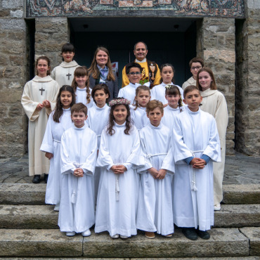 Erstkommunion in Gstaad - Elf Kinder feierten am vergangenen Sonntag Erstkommunion. Auf dem Bild sind sie von den Messdienerinnen und dem Messdiener sowie von der Religionspädagogin Martina Zechner umrahmt, die sie auf das Fest vorbereitet hat. Vielsprachig wie immer führte Pfarrer Alexander Pasalidi durch den Gottesdienst.  (Foto: zvg)