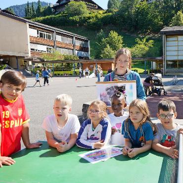 Spiel- und Sporttag der Schule Rütti: Altbekanntes und einige Neuerungen - Die Gruppe Katze lauscht der Einführung beim Posten.