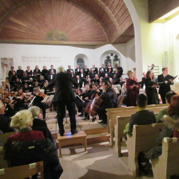 Mozart als Quelle für Kraft und Zuversicht - Die Kirche Zweisimmen, mit ihrer gewölbten Holzdecke eignet sich akustisch sehr gut für ein Chorwerk, und auch visuell kommen die Konzertbesucher auf ihre Rechnung. Wunderschön binden sich das Kammerorchester und der Chor mit den Solisten in das Kirchenchor mit der dekorativen Rosette im Hintergrund. 