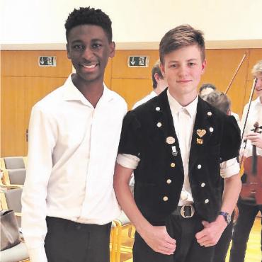 Länderübergreifende Harmonien - Sind auf den Konzertreisen Freunde geworden: Samuel Igbo aus Texas, der unter anderem in den Youth Orchestras of San Antonio Philharmonic Geige spielt (links), und der 13-jährige Janne Kernen aus Saanenmöser, der seit drei Jahren Alphorn bei Dominik Ziörjen lernt.