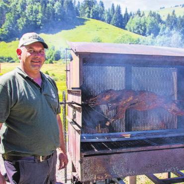 Jagd ist mehr als das Erlegen von Tieren - Markus Hauswirth, OK Präsident des Jubiläumsfestes neben dem auf dem Holz gegrillten Wildschwein..