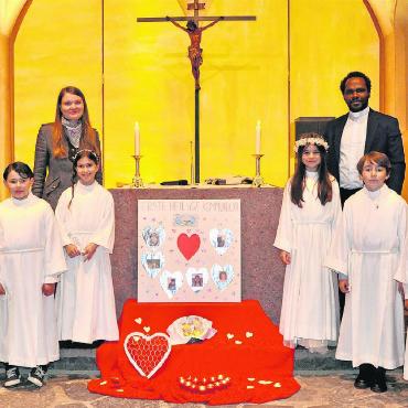 Erstkommunion in der Pfarrei St. Josef Gstaad - Erstkommunikant*innen, Kaplan Didier Nyongo und die Religionspädagogin Martina Zechner. FOTO: ZACHARIAS BORER