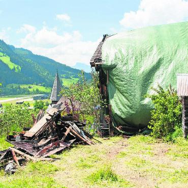 Zweifamilienhaus in Vollbrand - Verbranntes aufgestapeltes Holz, eingepacktes Haus: Das Gebäude nach dem Brand. FOTO: KEREM MAURER