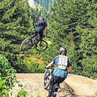 Junge, temperamentvolle Downhill-Biker heben ab