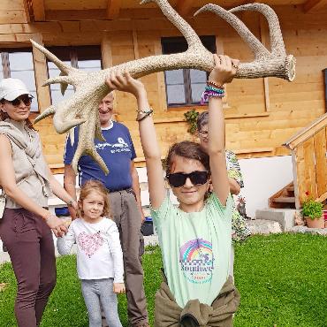 Rothirsch Leon empfängt Feriengäste - Ein Mädchen hebt voller Stolz das 5kg schwere Geweih. FOTOS: EUGEN DORNBIERER-HAUSWIRTH