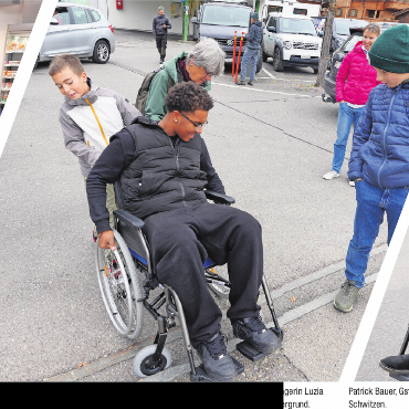 Barrieren sichtbar machen - Als Louis, William und Mathis aus der Schule Gsteig-Feutersoey die Barrierefreiheit testeten, kam Fussgängerin Luzia Perreten spontan zu Hilfe und half über die Schwelle, beobachtet von Lehrerin Stefanie Herrmann im Hintergrund.