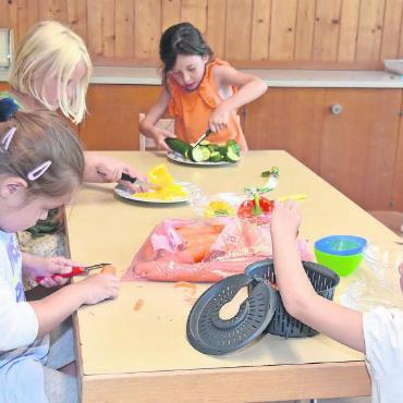 Ferienbetreuung – mehr als ein Herzensprojekt - Das Kochteam schnipselt das Gemüse.