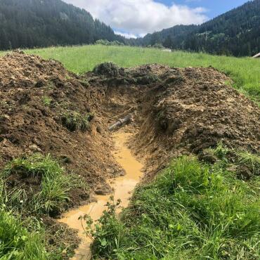 Bevölkerung spricht Kredit für neue Trinkwasserhauptleitung im Saali - Offener Graben im Saali: Das Zementfaserohr der Hauptwasserleitung erlitt in den letzten Jahren immer wieder Leitungsbrüche. (Foto: Gemeinde Gsteig/Ruedi Kistler)