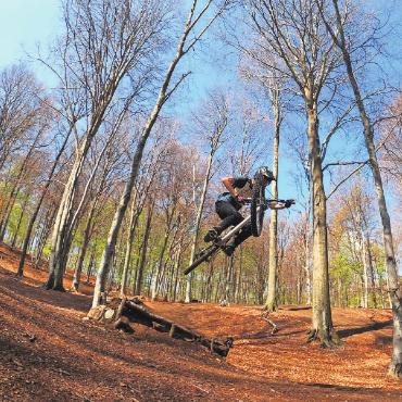 Junge, temperamentvolle Downhill-Biker heben ab