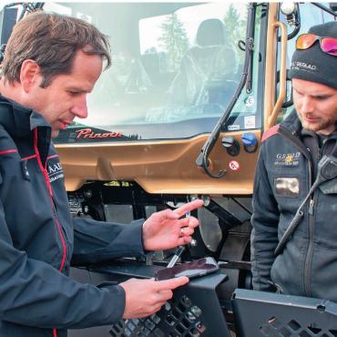«Ich darf in einer Region arbeiten, die ich sehr schätze» - Matthias In-Albon (links) diskutiert mit Max Locher, Mitarbeiter Seilbahntechnik, über die zukünftigen Chancen der E-Pistenfahrzeuge mit Feststoffbatterien, welche ab 2027 auf den Markt kommen werden und welche im Sommer sogar als mögliche Stromspeicher genutzt werden können.