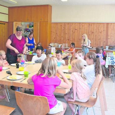 Ferienbetreuung – mehr als ein Herzensprojekt - Geduldig warten die Kinder, bis das Mittagessen serviert ist.
