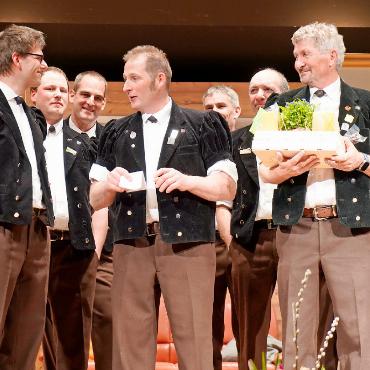 Übergabe des Dirigentenstabs und ein witziger Zweiakter - Präsident Benjamin von Grünigen (Mitte), der neue Dirigent und Nachfolger von Jürg Domke (rechts), Reto Stadelmann (links).