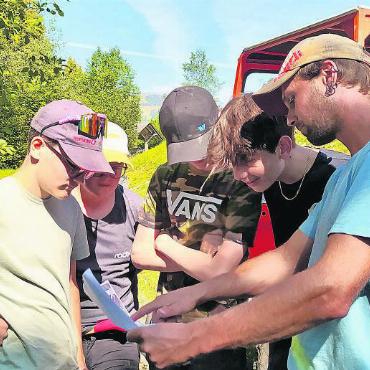 Projektwoche «Renaturierung Schürmattbach» der 9b des OSZ Ebnit - Daniel Ziörjen erklärt Luca, Nick, Lenni und Dario die nächste Arbeit.
