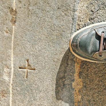 Kirchenserie Teil 2: Heilige Mauritius & Joder: der Märtyrer, der Bischof und ein Massengrab - Die Steinplatte eines katholischen Altars – mit eingeritztem Weihkreuz – wurde nach der Reformation am Eingang zum Chor in die Bodenpflästerung integriert, damit sie mit den Füssen getreten werde.