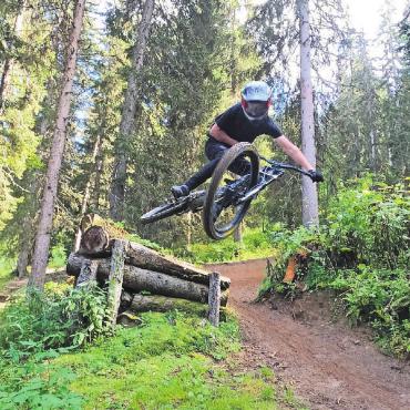 Junge, temperamentvolle Downhill-Biker heben ab