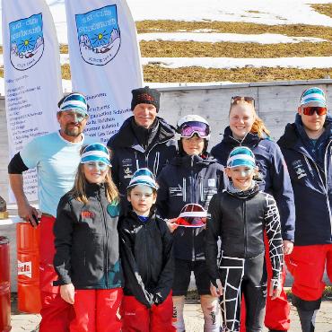 Saisonschluss für den Skiclub Schönried - Unsere Clubmeisterinnen und Clubmeister 2026 umrahmt von den beiden Rennchefs Mike Haldi und Matthias Zürcher.