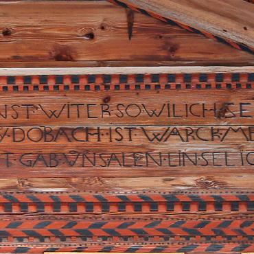 Glodo Dubach und die königlichen Blüten am Säumerweg - Auch an der Fassade des Boo-Hauses erzeugt die für Glodo Dubach charakteristische Kombination aus Schriftband und rot-schwarzem Schachbrettmuster ein eigentümliches, modern anmutendes Gesamtbild.