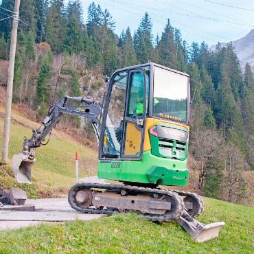 Fahrverbot, Barriere, Parkplatzbewirtschaftung: Lauenen reagiert auf Touristenströme - Auf der Bochte an der Lauenenseestrasse gräbt der Bagger einen Graben für die Stromversorgung. Dahinter kommt die Barriere von der Bergseite her über die Strasse, rechts bleibt Raum frei Fussgängerinnen und Fussgänger.