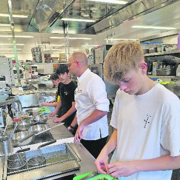 Hinter den Kulissen des The Alpina Gstaad - Unter Anleitung von Sous-Chef Klaus Menze bereiten Schüler der Schule Gsteig-Feutersoey das Mittagessen zu. FOTO: OLIVER HERRMANN