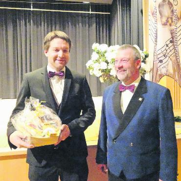 Blasmusik aus vier Himmelsrichtungen - Nicht nur mit lobenden Worten, sondern auch mit einem dankbaren Gesichtsausdruck überreichte Jürg Dupertuis (rechts) dem Dirigenten Joel von Siebenthal einen wertvollen Geschenkkorb. FOTOS: VRENI MÜLLENER