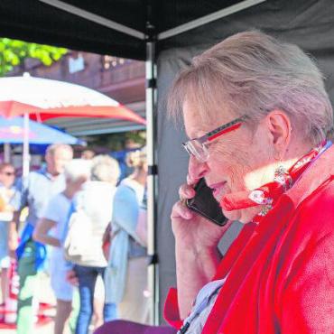 Von der Alp ins Dorf: Fotostrecke Gstaad Züglete 2023 - Moderatorin Léonie Müller informierte die Zuschauenden über die verschiedenen Zügleten. Und wenn eine im Anmarsch war, erhielt sie das Telefon.