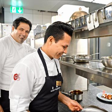 Kochen für eine bessere Zukunft - Und auch der 25-jährige Fidel Geovanny Grefa Aguinda hilft beim Anrichten des Abendessens tatkräftig mit. Küchenchef Giuseppe Colella (hinten) ist voll zufrieden mit seinen Schützlingen.