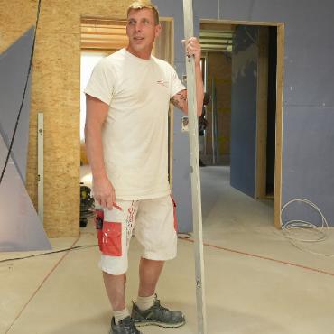 Im Estrich entsteht Raum für eine WG - Vorarbeiter Danilo Kasch, Werren AG, bei Arbeiten an den Wänden im Wohnzimmer der WG.