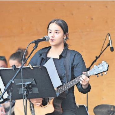Musik im Pavillon drang auf die Promenade - Es ist nicht jedermanns Sache, alleine auf der Bühne zu stehen. Aber die Solistin im Bild brillierte mit einer tollen Stimme und damit, sich selber auf der Gitarre zu begleiten.