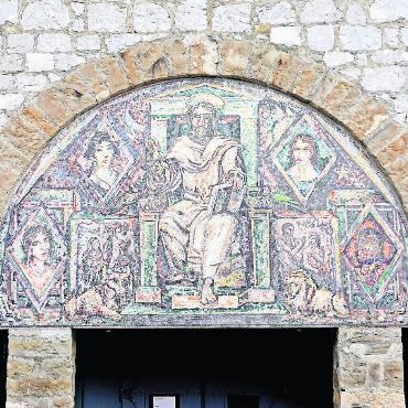 Der heilige Josef: der Zimmermann von Nazareth, ein Genfer Abbé und das rätselhafte Schächtelchen - Das Mosaik über dem Eingangsportal wurde wie die Farbglasfenster vom Genfer Künstler Marcel Poncet (1894–1953) gestaltet. In der Mitte thront Jesus Christus als Weltenherrscher, links unten sind Josef und Maria dargestellt, rechts Adam und Eva im Paradies. Die Tiere (Ochse, Löwe, Adler) sind die Symbole der Evangelisten. Die Porträts rundherum stehen für die Menschentypen der verschiedenen Erdteile.