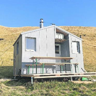 Mit 500 Schafen «z Bärg» - Die mobile Hirtenunterkunft wird zu Beginn des Sommers zusammen mit haltbarem Proviant auf die Alp geflogen. So kann Daniel Reichenbach auch länger bei den Schafen und Herdenhunden bleiben. FOTO: ZVG