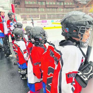 Swiss Ice Hockey Day auf dem Eisfeld in Gstaad - Von der Bande aus beobachten die Eishockeyfans alles ganz genau.