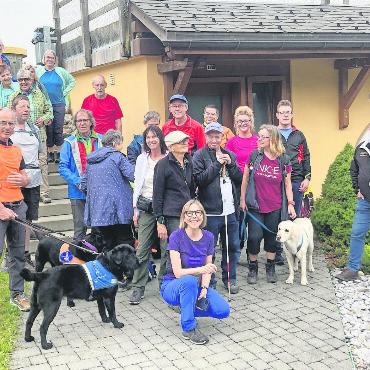 Borters feine Wanderwoche für Blinde - Die Blinden und Sehbehinderten beim König des Käses in der Käsegrotte: kniend Daniela Borter, links mit Hund Daniel Borter, rechts René Ryser, Geschäftsführer Molkerei Gstaad. FOTO: ZVG