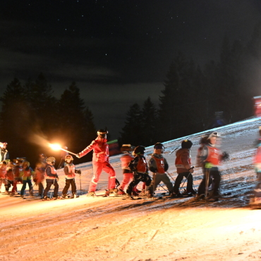 Mehr als nur eine Skischule – eine Bewegung für das Saanenland - Die Skischule Gstaad bei der Fackelabfahrt, nachdem sie mit einheimischen Kindern eine Pastaparty im Berghaus Eggli gefeiert hatte.