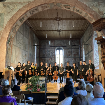 Aufforderung zum Nachdenken - Die Musikerinnen und Musiker der Camerata Bern und René Liebert (graues Hemd, Mitte) begeisterten das Publikum in der Kirche Saanen. (Foto: AvS)