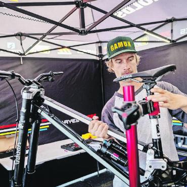Schaufeln fürs Herzensprojekt - Am Weltcup in Mont-Saint-Anne in Kanada 2023 bereitet Weltcupmechaniker Cairoli das Bike gerade für den Rennlauf vor.