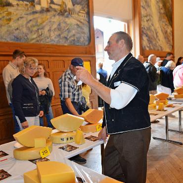Ein Dorf im Käsefieber: Berner Alpkäsemeisterschaft in Saanen - Mit Zahnstochern bewaffnet defilieren Besucherströme an den eingereichten Käselaiben vorbei und probieren fleissig. Lecker!