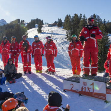 Mehr als nur eine Skischule – eine Bewegung für das Saanenland - Michael Zimmermann (zu oberst auf dem Podest) verkündet die Resultate eines Schülerskirennens.