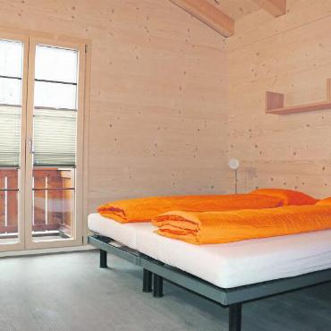 Mit Schreibtisch, Bett und Tresor - Kein unnötiger Schnickschnack: Die Zimmer der Sport Lodge sind praktisch und zweckmässig eingerichtet.
