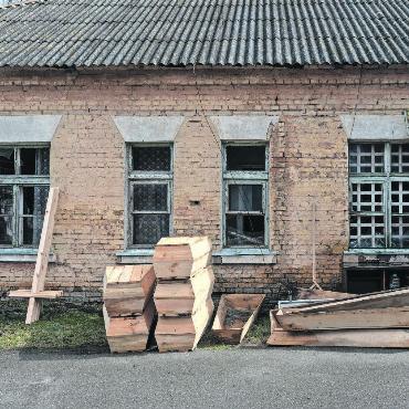 Alex Kühni hat den Krieg im Fokus - Vorgefertigte Särge in einem Innenhof der ukrainischen Stadt Makariw nach dem Rückzug russischer Truppen aus dem Oblast Kiew, im April 2022. FOTO: ALEX KÜHNI
