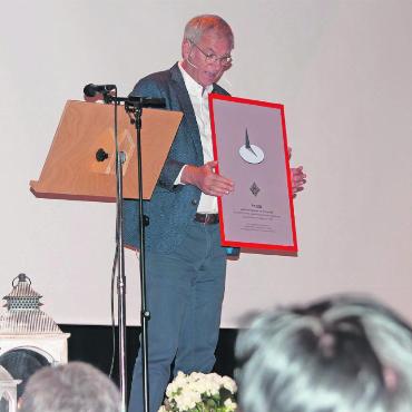 ZEDER – die Plakatausstellung ist eröffnet - Markus Iseli, Leiter der Arbeitsgruppe und Moderator des Eröffnungsanlasses, präsentiert die ZEDER-Gedenktafel. Entworfen vom Berner Grafiker Claude Kuhn, zeigt sie einen Reissnagel, der stellvertretend für die Zwiespältigkeit der Erinnerung steht. Einerseits kann es schmerzen, sich an Vergangenes zu erinnern, andererseits aber auch helfen zu heilen. Ähnlich verhält es sich mit einem Reissnagel: Er kann Schmerz auslösen, aber auch hilfreiches Werkzeug sein. FOTO: KEREM MAURER