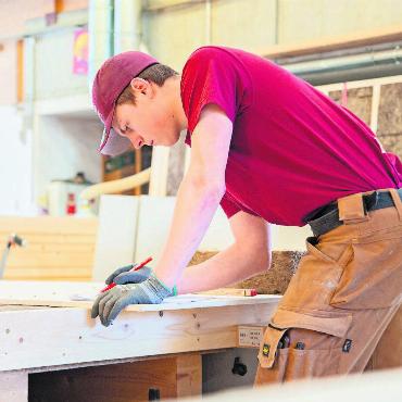 Der Stolz, mit den eigenen Händen etwas zu erschaffen - Philipp Reber kontrolliert die Pläne von Holzwänden, die er aus Holz und Isolationsmaterial komplett selbst anfertigt.